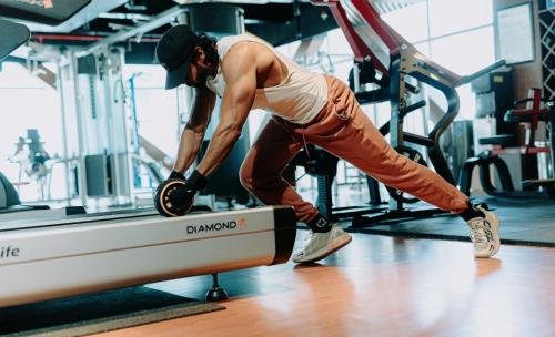 a man in a gym with his foot on a treadmill at The Peninsula Chittagong Limited in Chittagong