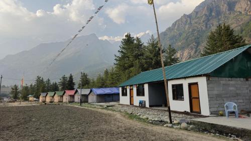 a row of houses with a mountain in the background at Sangla Valley Camping in Saturang