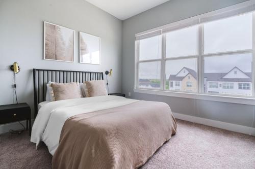 a bedroom with a large bed and two windows at Blueground Lost Plains parking gym pool wd ATX-261 in Austin