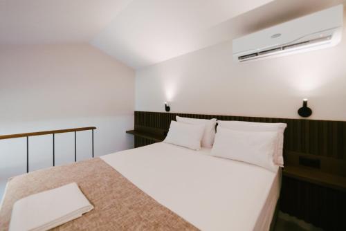 a bedroom with a bed with white sheets and pillows at LAN-GO SIVOTA Luxury Living in Sivota