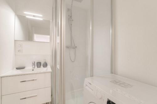 a white bathroom with a shower and a sink at Cosy au centre d’Oullins avec garage in Oullins