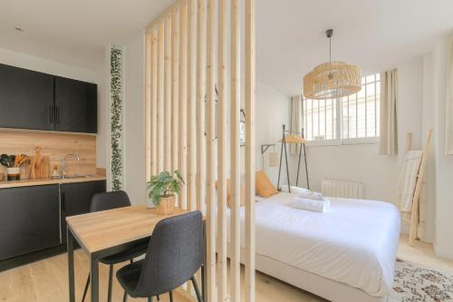 une chambre avec un lit et une table et une cuisine dans l'établissement Le cosy en hypercentre, à Lyon