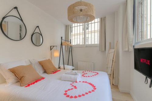 - une chambre avec un lit blanc orné de fleurs rouges dans l'établissement Le cosy en hypercentre, à Lyon