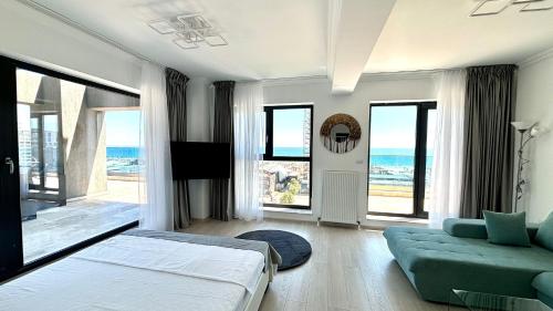 Un dormitorio con una cama y un sofá y ventanas. en North Club Apartments II, en Mamaia