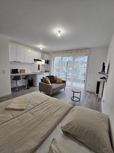 une chambre avec un grand lit et un salon dans l'établissement Studio cosy situé à Bois Colombes, à Bois-Colombes