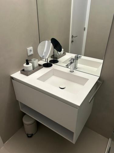 a bathroom with a white sink and a mirror at Seeblick Appartements Henle in Bregenz