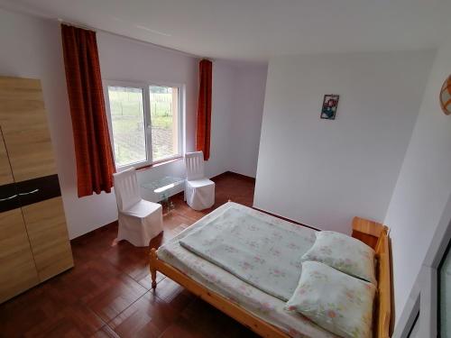 a small bedroom with a bed and a window at Casa din Vamă in Vama Veche
