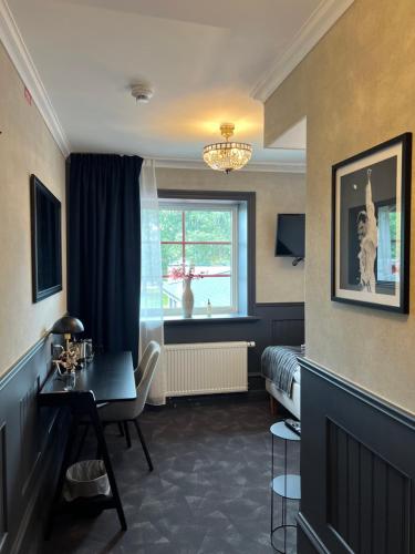 a room with a table and a bed and a window at Central Hotellet Tierp in Tierp