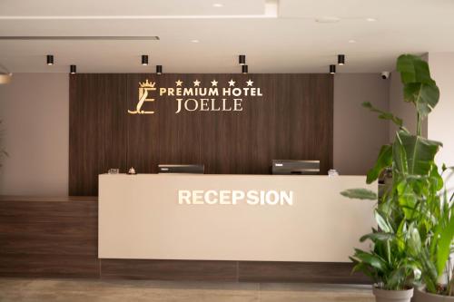 a reception desk with a sign that reads premium hotel jouce at Joelle Premium Hotel in Sarandë