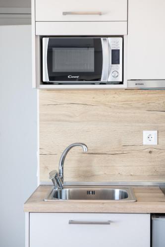 a kitchen with a sink and a microwave at RoofTop Sea View Cabin in Vari