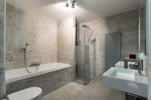 a bathroom with a tub and a toilet and a sink at Kabbelaarsbank 405 - Port Marina Zélande NOT INTENDED FOR COMPANY OR WORK-RELATED STAYS in Ouddorp