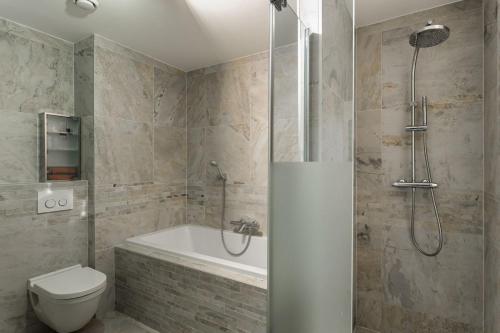 a bathroom with a tub and a toilet and a shower at Kabbelaarsbank 405 - Port Marina Zélande NOT INTENDED FOR COMPANY OR WORK-RELATED STAYS in Ouddorp