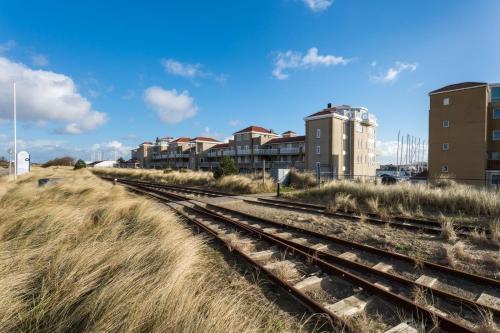 a set of train tracks in front of buildings at Kabbelaarsbank 405 - Port Marina Zélande NOT INTENDED FOR COMPANY OR WORK-RELATED STAYS in Ouddorp
