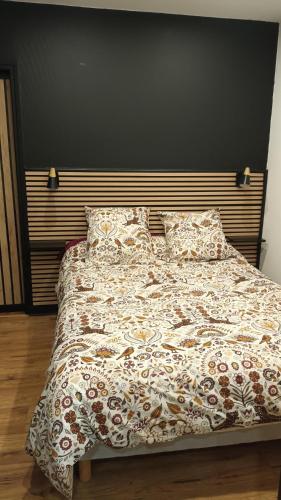 - un lit avec une couverture et des oreillers dans une chambre dans l'établissement superbe appartement T2 proche de vulcania, à Pontaumur