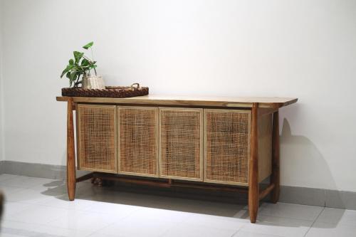 a table with wicker doors and a plant on top at Lela Stay in Tuy Hoa