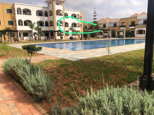 a swimming pool in front of a building at Salicorne Saidia avec piscine in Saidia 