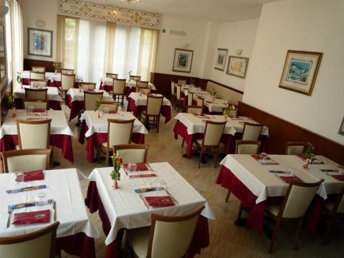 a dining room with white tables and chairs at La Volpe Pescatrice in Castellanza