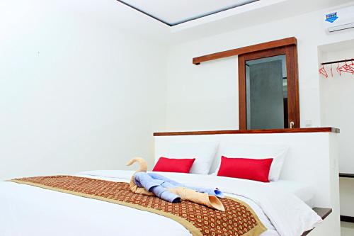 a bedroom with a bed with a stuffed animal on it at Alam Mimpi Hotel in Senggigi 