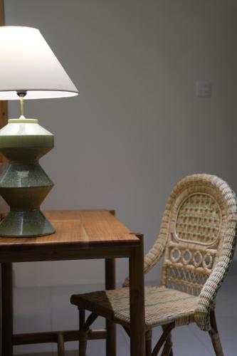 a table with a chair and a lamp on it at Lela Stay in Tuy Hoa