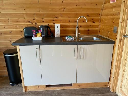 a kitchen with white cabinets and a sink at Glenview Lodge in Portree
