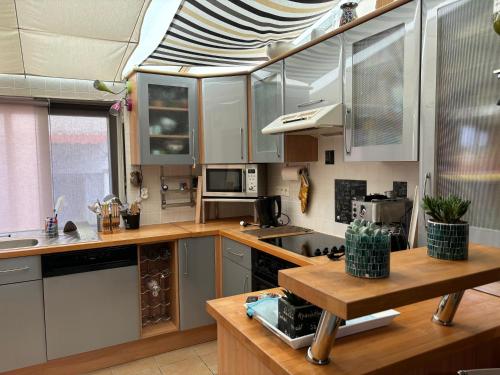 une cuisine avec des armoires blanches et un comptoir dans l'établissement Maison Ile d'oleron 10 min de la plage à pied, parking et jardin, à Foulerot