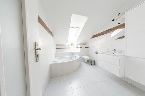 biała łazienka z wanną i umywalką w obiekcie Wellness apartmány Fürst w mieście Nová Lipnica