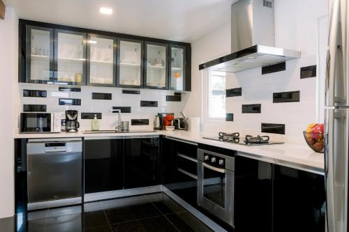 a kitchen with black and white tiles on the wall at Luxurious Residence Rawai in Phuket Town