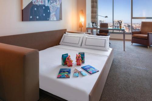 a bed in a hotel room with books and toys on it at Melia Valencia in Valencia