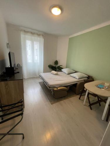une chambre avec un lit, une table et une fenêtre dans l'établissement À 2 pas du centre, à Nice