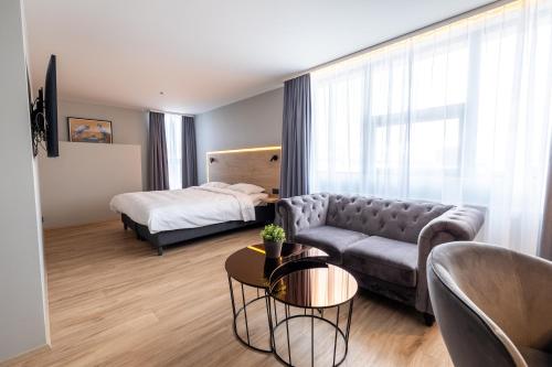a living room with a couch and a bed at Park Inn by Radisson Reykjavik Keflavík Airport in Keflavík