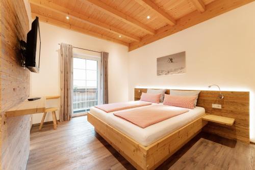 a bedroom with a bed in a room with a window at SCHMID Ferienwohnungen in Ofterschwang