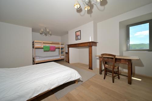 a bedroom with a bed and a desk and a table at Toulal'o - Saint Lary Soulan in Saint-Lary-Soulan