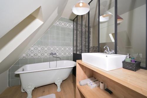 a bathroom with a white tub and a sink at Toulal'o - Saint Lary Soulan in Saint-Lary-Soulan