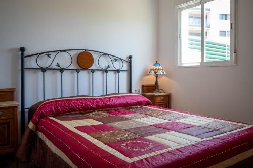 une chambre avec un lit avec une couette dessus dans l'établissement AT077 Planta baja con jardín privado, à Torredembarra