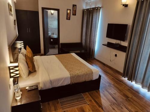 a hotel room with a bed and a television at Pearl suites at Omaxe entrenity in Vrindāvan