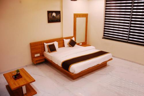 a bedroom with a large bed and a table at Hotel Wing Orbit in Bāli