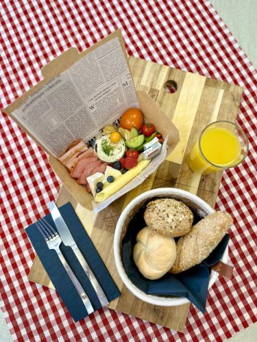 a table topped with a box of food and a bowl of bread at Numa Salzburg Vogelweider in Salzburg