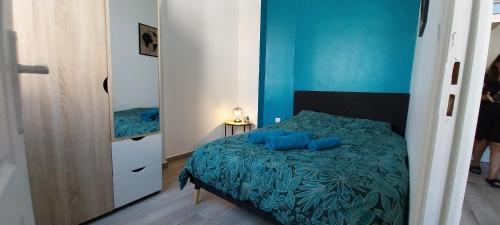 une chambre avec un lit avec des draps bleus et un miroir dans l'établissement Charmant 2 pièces, à Nice