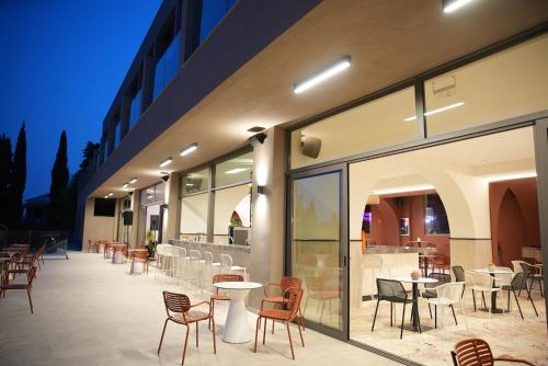 a patio with chairs and tables and a building at Iolida Corfu Resort & Spa by Smile Hotels in Dassia