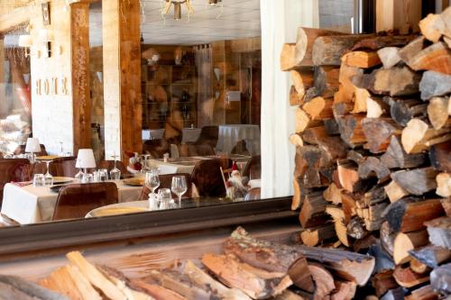 a restaurant with a pile of logs on the wall at Domaine de l'Adoux in Saint-Jean Montclar