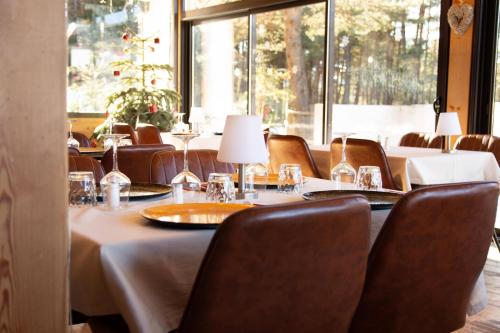 a dining room with tables and chairs and a large window at Domaine de l'Adoux in Saint-Jean Montclar