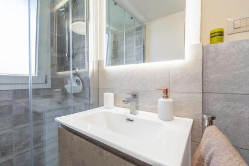 een badkamer met een witte wastafel en een douche bij Lucca Old Town Apartment in Lucca