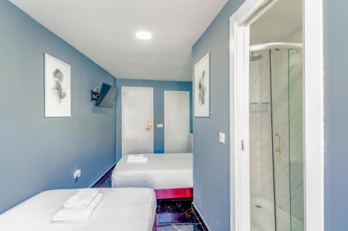 a small room with two beds and a shower at SL Marbella in Marbella