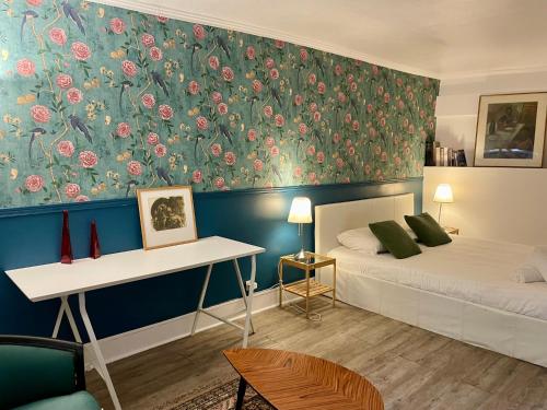 - une chambre avec 2 lits et un mur orné de fleurs dans l'établissement Elegant Triplex - Tour Eiffel Invalides, à Paris