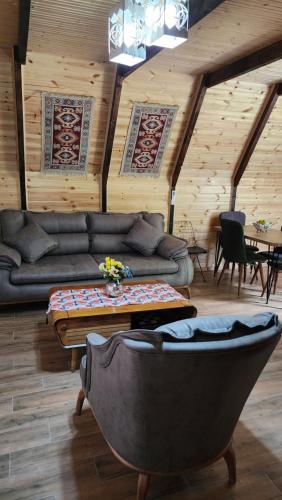 a living room with a couch and a table at Ecohouse Machakhela 4 in Machakhela