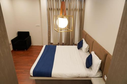 ein Schlafzimmer mit einem großen Bett mit blau-weißer Bettwäsche in der Unterkunft Hotel Suryodaya in Ujjain