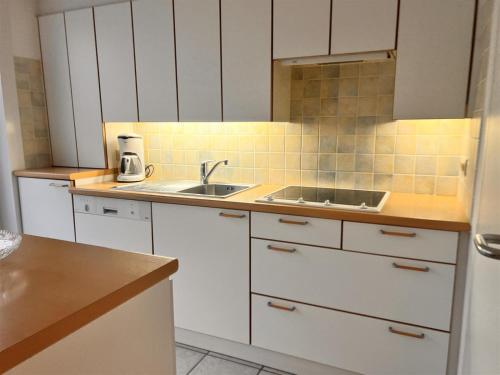 a kitchen with white cabinets and a sink at Barkas 18 in Nieuwpoort