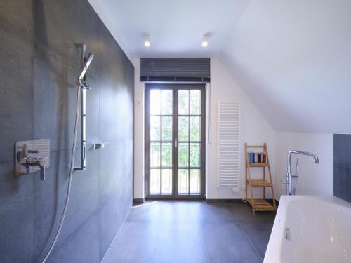 a bathroom with a shower and a bath tub at Reetland am Meer - LuxusPlus Reetdachvilla mit 4 Schlafzimmern, Außensauna, Loungebereich und Kamin H05 in Dranske