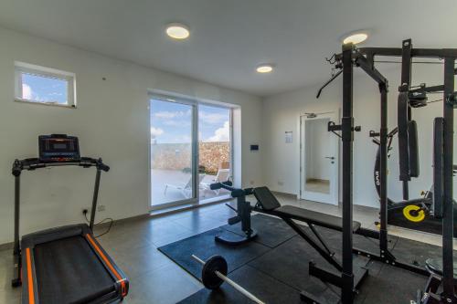 a room with a gym with two tread machines at Wellness Hygge Modern Gozitan Apartment - Happy Rentals in Taʼ Sardina