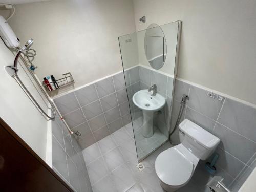 Un baño con inodoro, lavabo y espejo. en work & chill 깨끗한 compact studio, en Lapu Lapu City